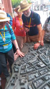 Teilnehmer inspizieren das taktile Modell einer Stadt