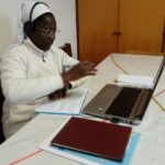 Schwester Pauline trägt ihre neue Korrekturbrille während des online-Unterrichts am Laptop