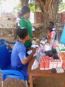 Ein junger Mann sitzt auf einem Stuhl. Zwei Frauen stehen vor ihm und führen eine Beratungsgespräch.