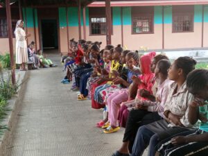 Die Schülerinnen und Schüler sitzen in Reihen in einem Raum